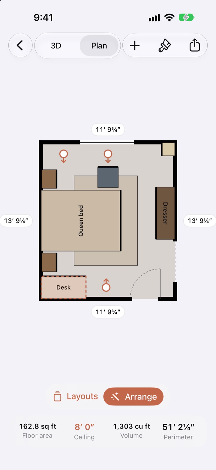 The bedroom plan while a desk is dragged: small markers with arrows show the spots where the desk fits and which way it would face, and the desk is outlined where it would snap into a corner.